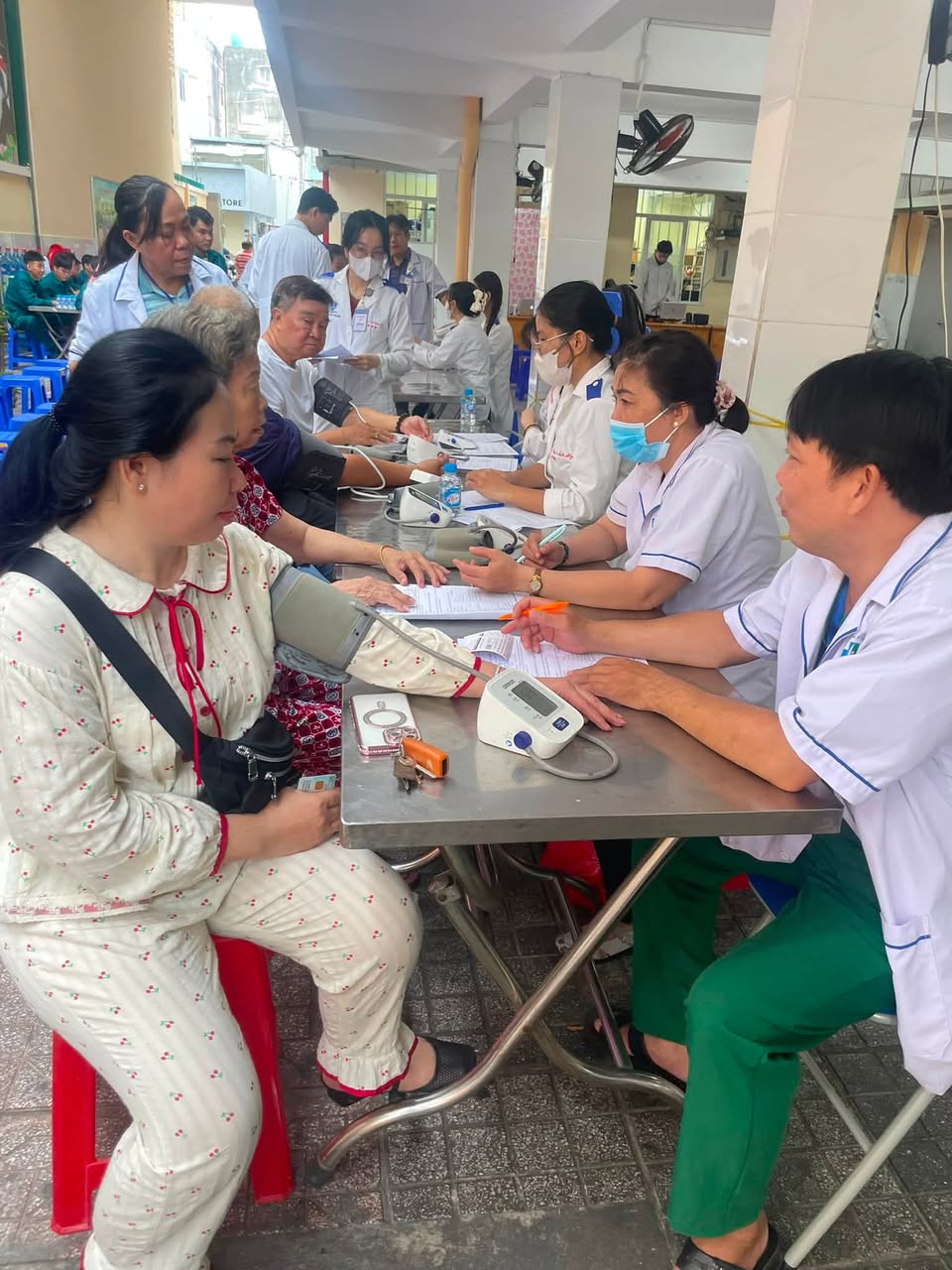 Đội ngũ y tế khám sức khỏe và đo huyết áp cho người dân tại Trường Tiểu học Nhật Tảo